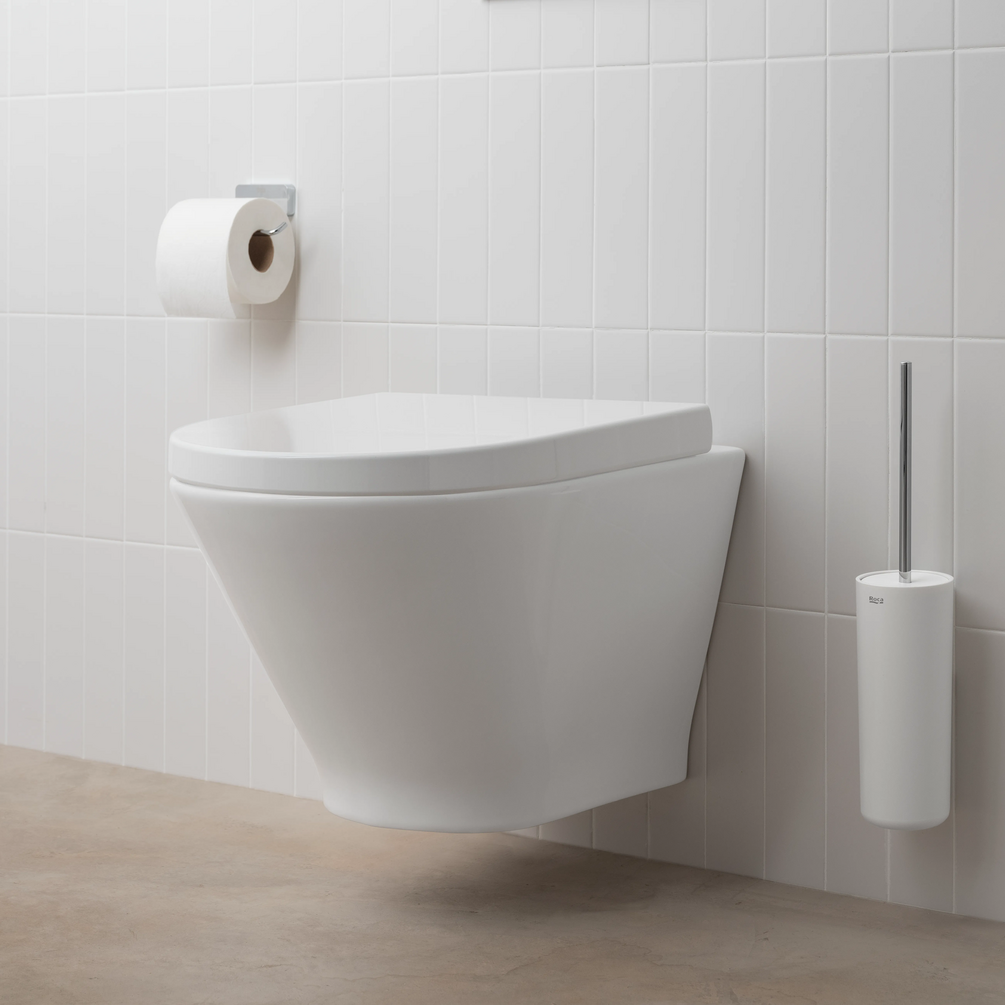 Lifestyle image of the Roca The Gap Round Wall Hung Compact Toilet mounted to a white tiled bathroom wall